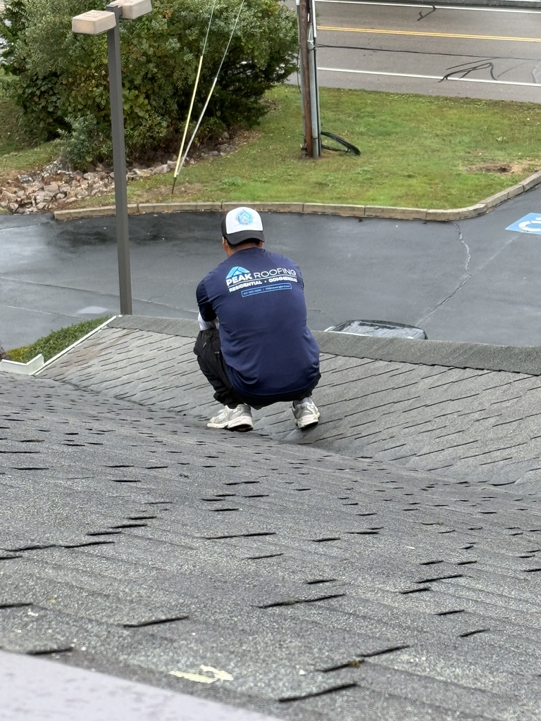 Peak Roofing technician inspecting shingles
